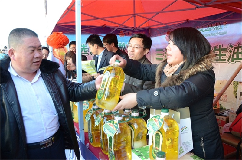 銷售人員向市民講解冷榨花生油的優(yōu)點